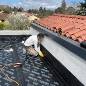 L'artisan travaille sur l'étanchéité d'un toit de garage