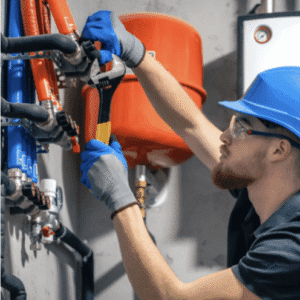 Plombier chauffagiste réglant un collecteur de chauffage sur réseau de tuyaux eau chaude et froide