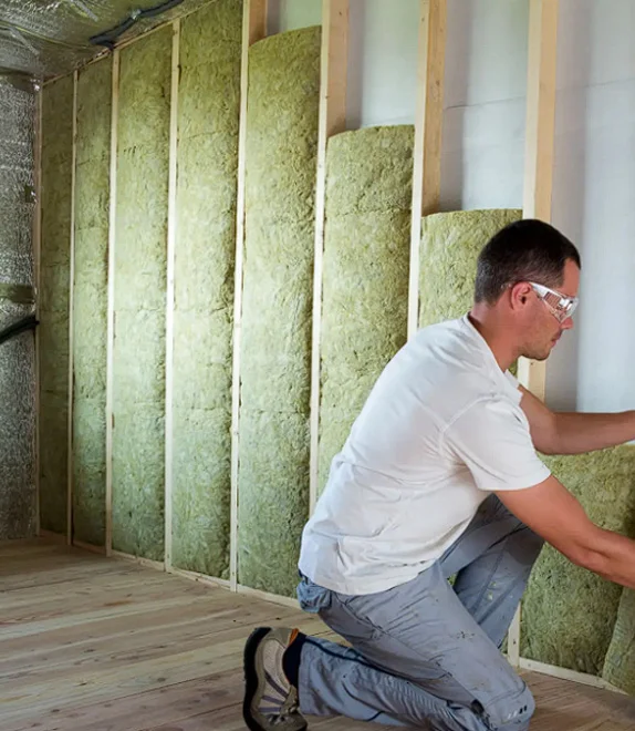 Pose d’isolant en laine minérale pour une isolation intérieure performante.